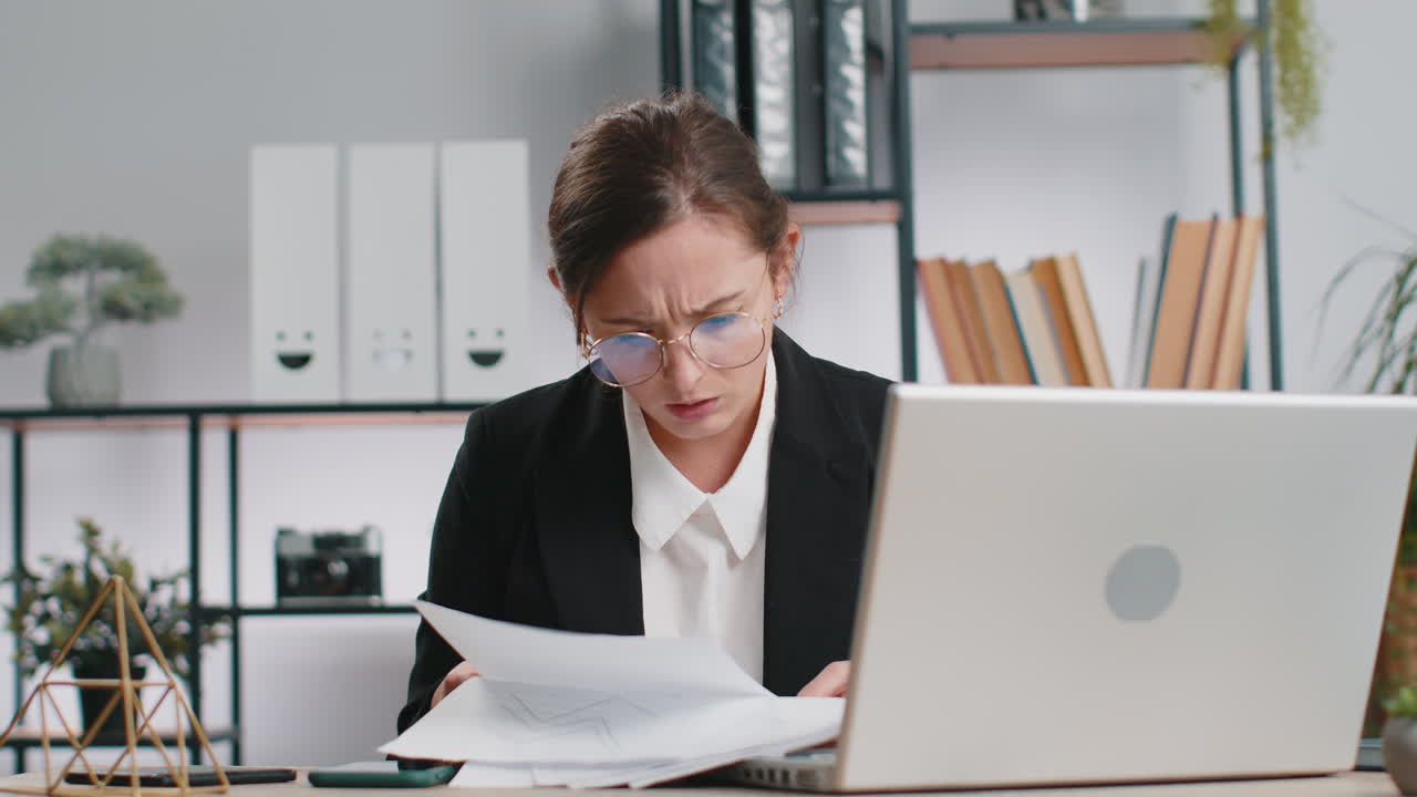 Stressvolle Geschäftsfrau arbeitet an unbezahlten Bankschulden, macht Papierarbeit, plant das Budget, wirft Papierrechnungen