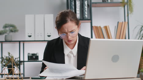 stressed businesswoman work at unpaid bank debt doing paperwork planning budget throws paper bills