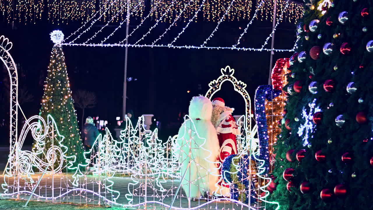 Families enjoy a magical display of holiday lights in the park. Colorful decorations include trees and themed figures, creating a cheerful atmosphere for all ages