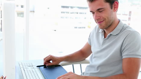 Graphic-designer-looking-at-colour-samples-at-his-desk