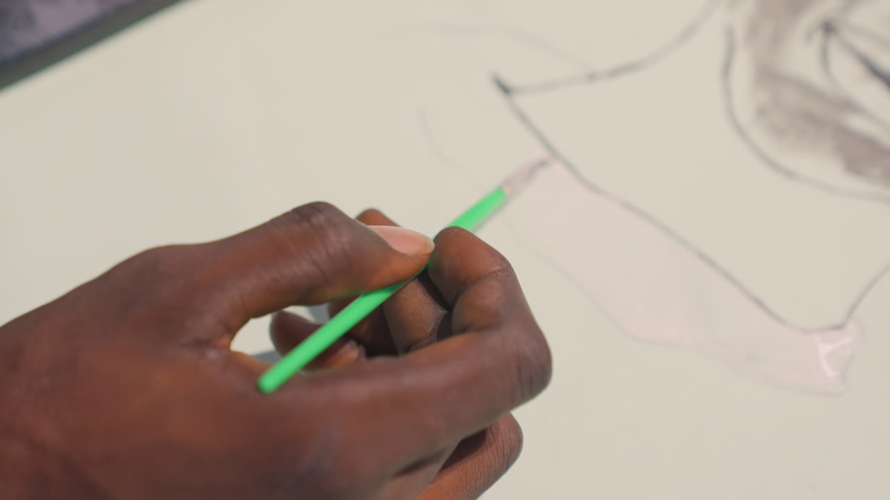 Green brush on paper. Pale wash applied with careful hand. Wet pigment blending during calm studio painting session. Deliberate hand movement creates subtle wash with green accents on paper