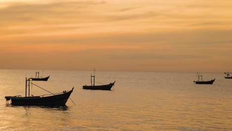 los barcos flotan pacíficamente bajo una puesta de sol vibrante.