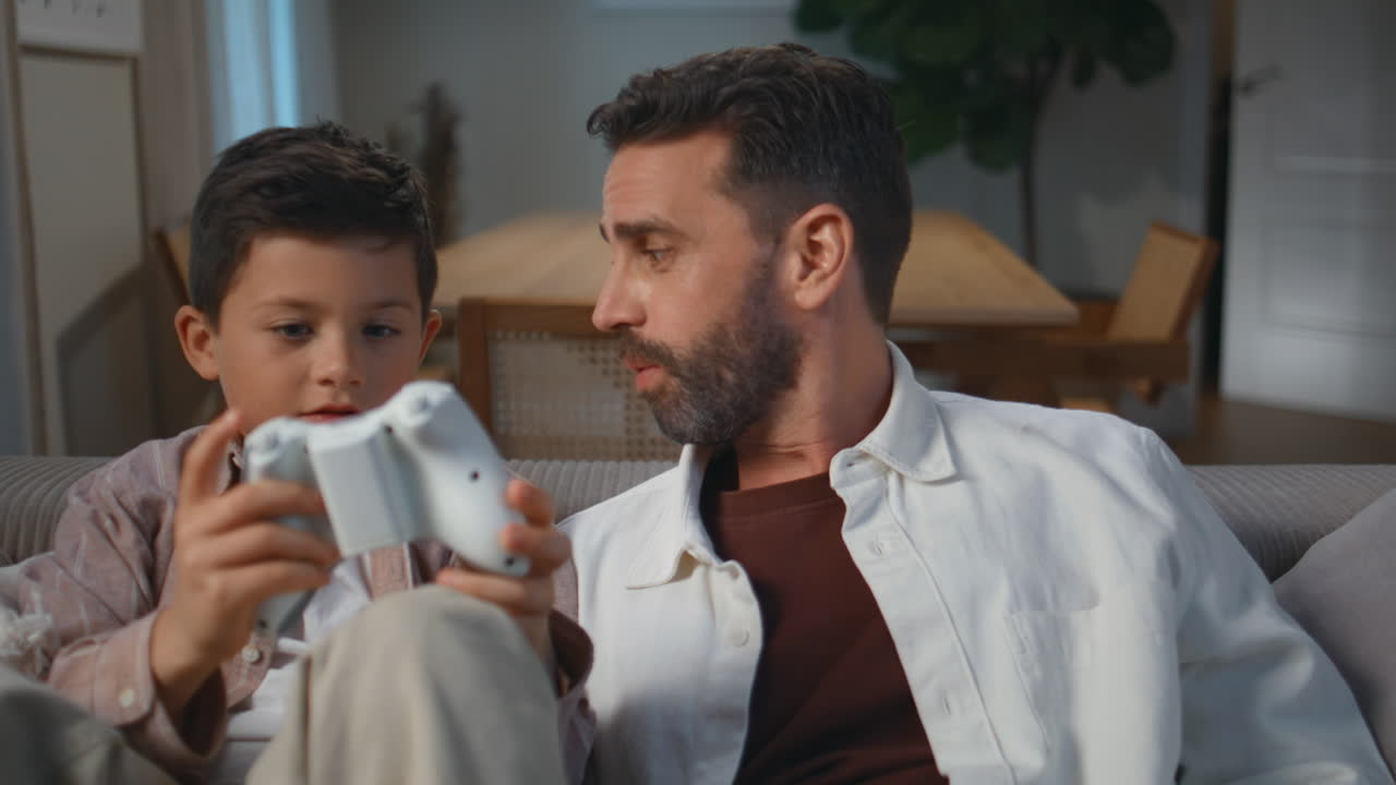 Relaxed dad boy conversation at evening interior closeup. Man child talking