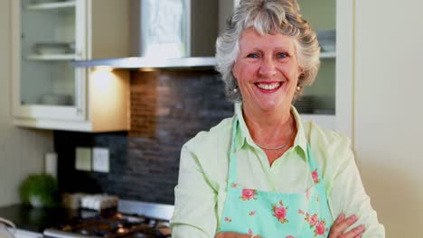 Senior-woman-standing-with-arms-crossed-in-kitchen-4k