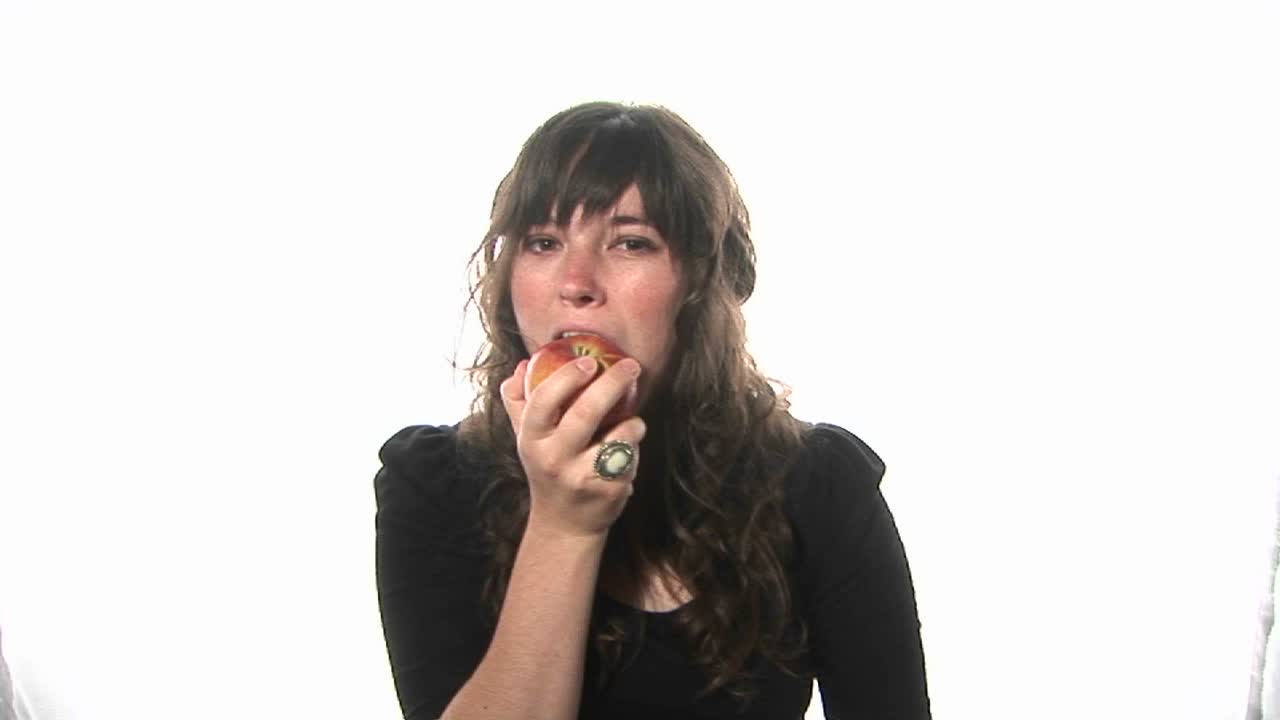 A woman eats an apple