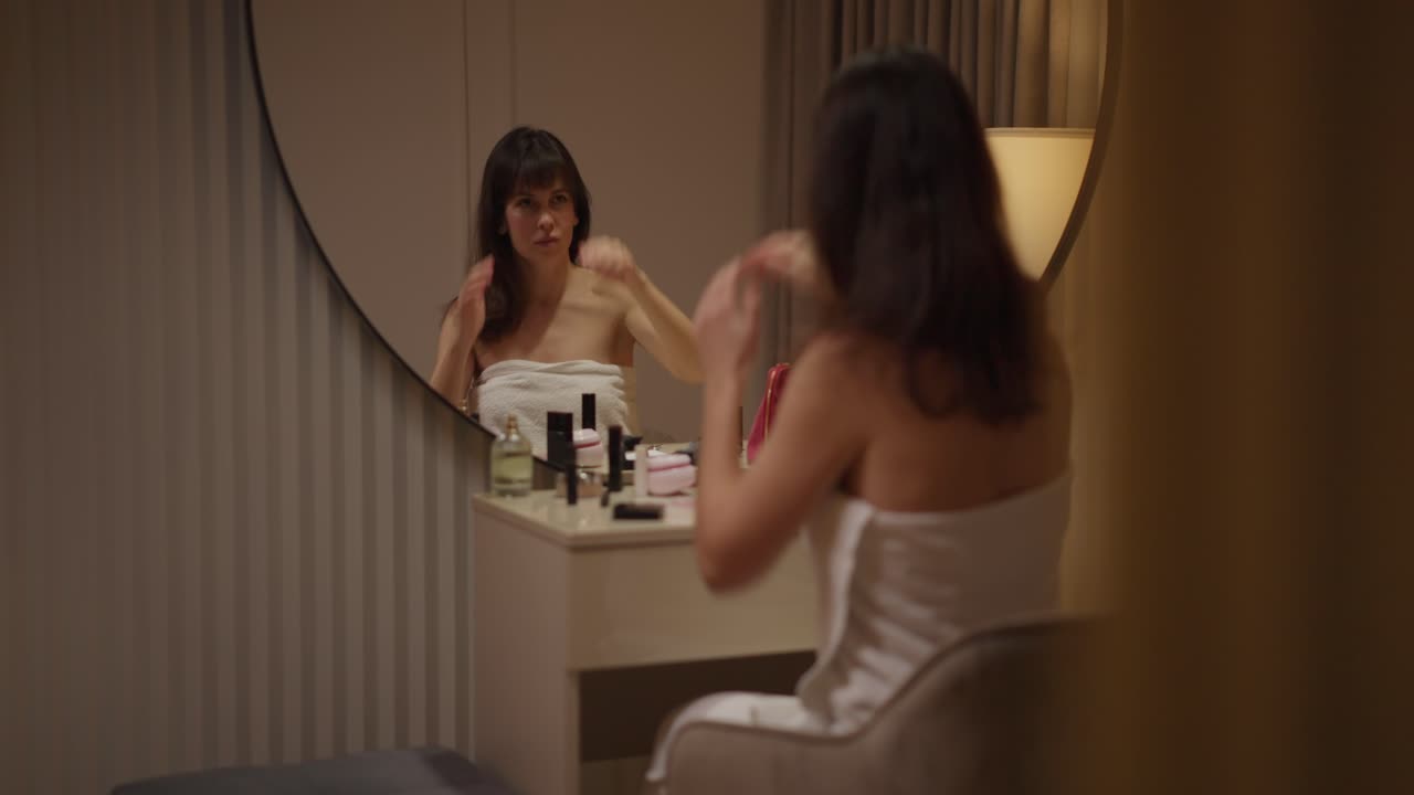 mujer aplicando maquillaje frente a un espejo