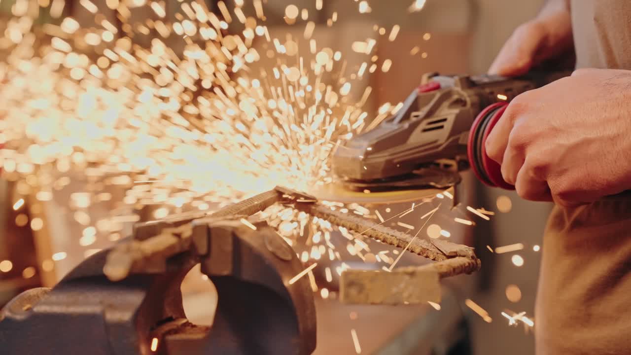 Worker grinding metal rod with sparks flying from angle grinder