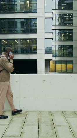 man walking and talking on phone in urban cityscape