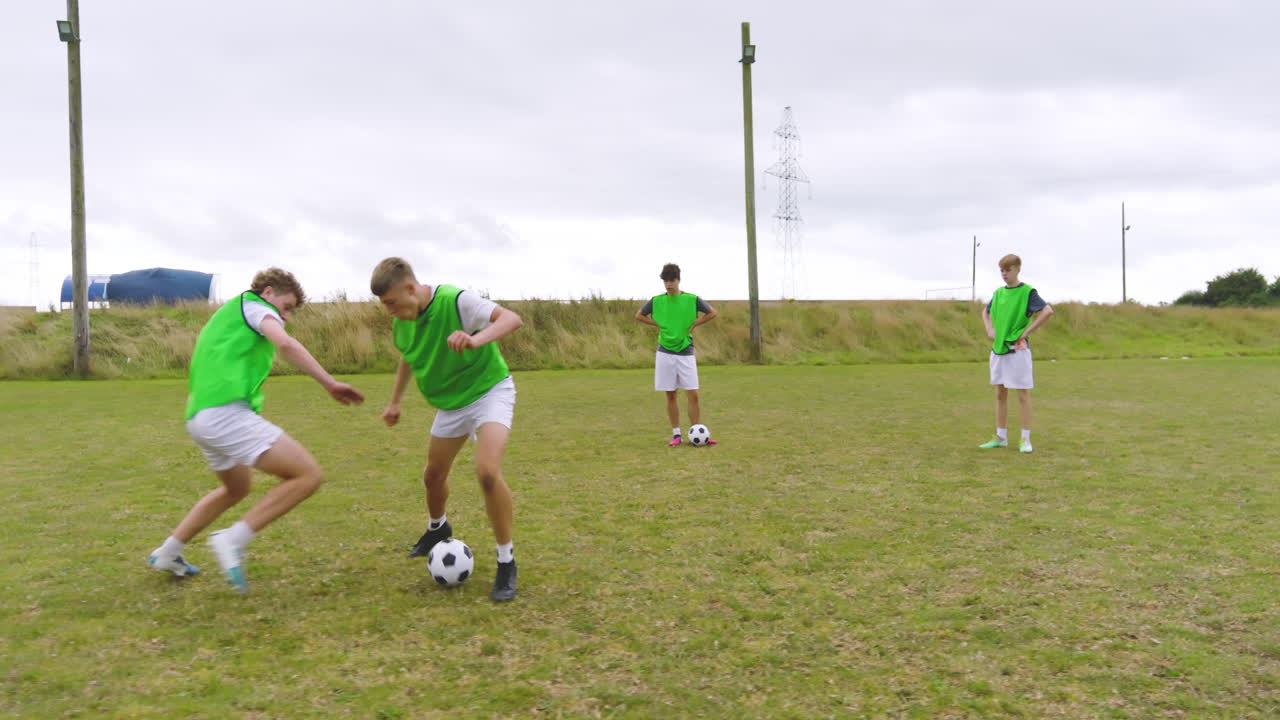 Male soccer players training, warming up and running after and passing ball on pitch