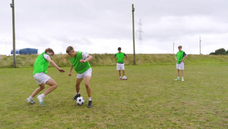 male soccer players training, warming up and running after and passing ball on pitch