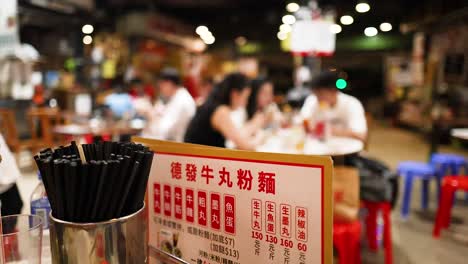 people enjoying food at a bustling street market