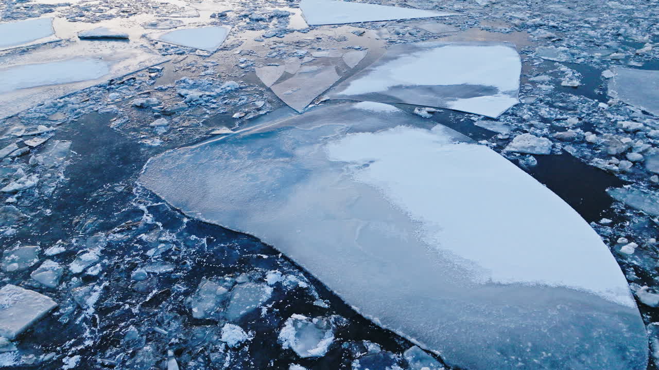 A drone flying above colossal ice masses on the water's surface