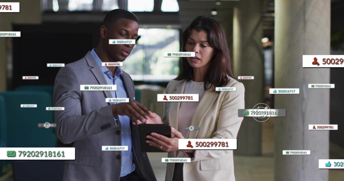 Man swiping and woman tapping tablet in office generating animated message icons for analysis