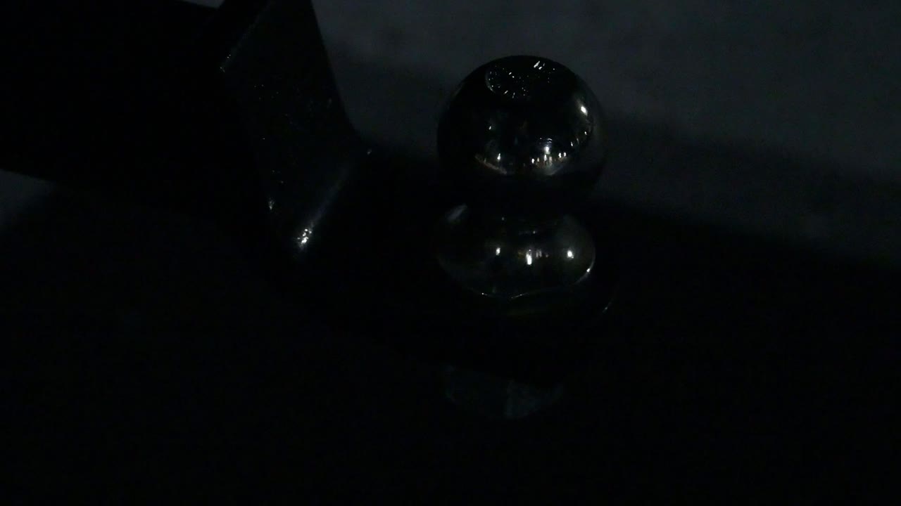 towing ball on a hitch lit by the flashing police light strobe blue and red