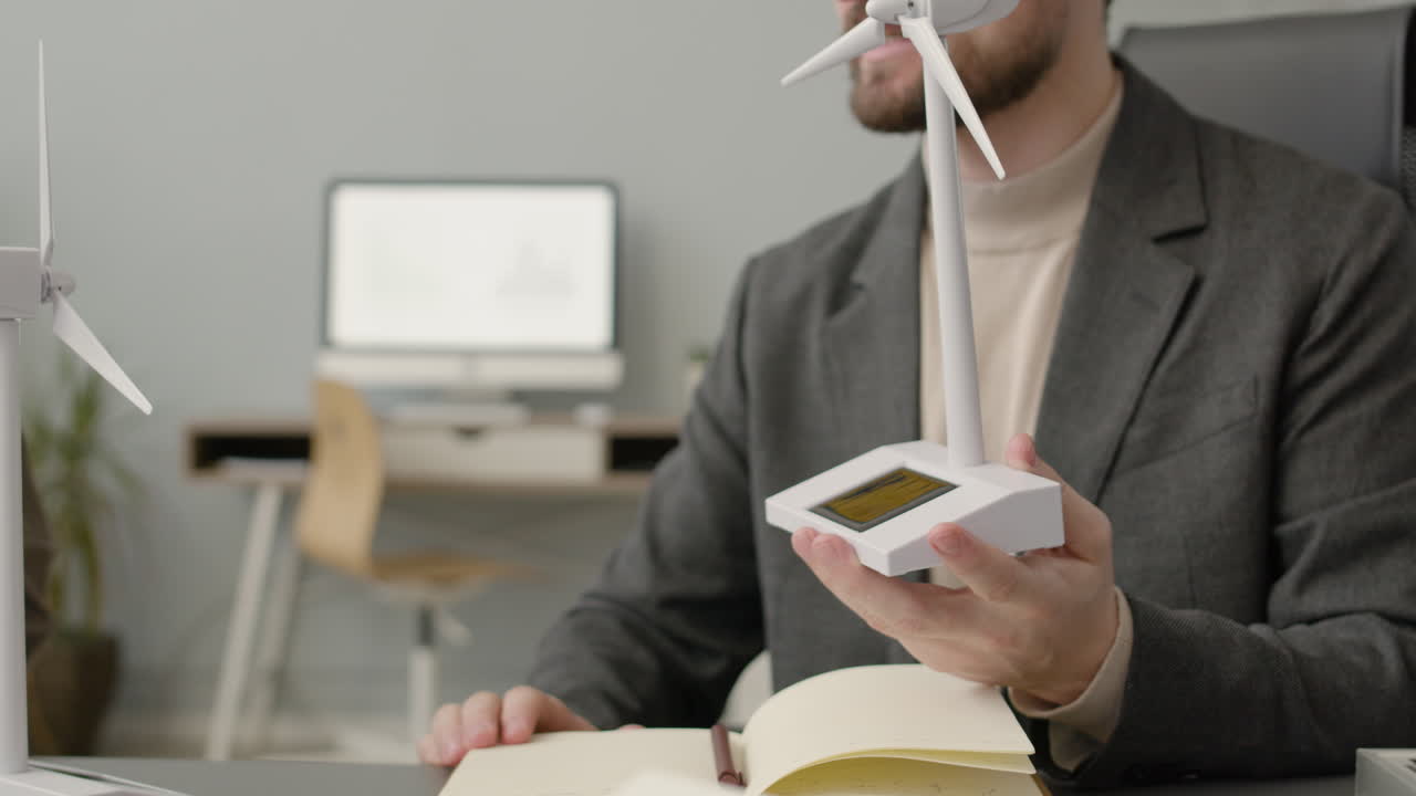 사무실 동료들에게 풍력 터빈 모델을 설명하는 사업가