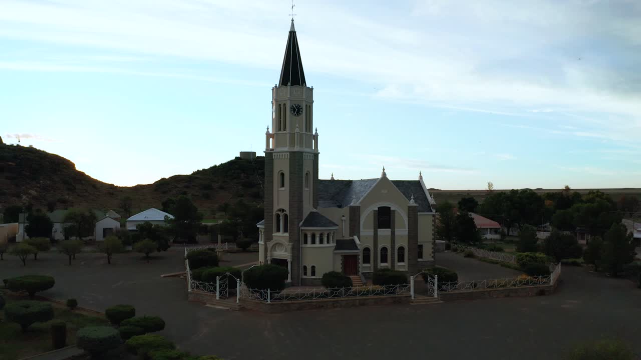 Small town house of religion, church in center of village, flying drone backward