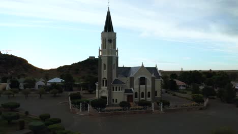 small town house of religion, church in center of village, flying drone backward