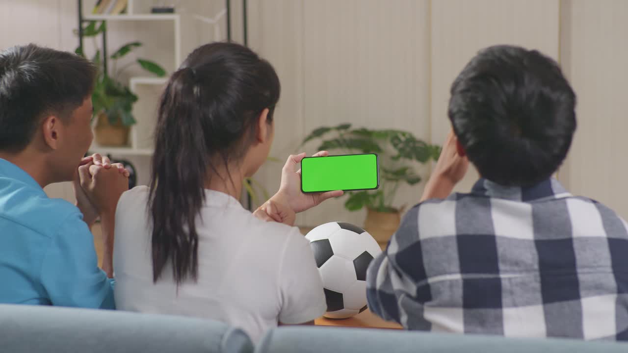 슬픈 아시아 십대 친구들이 집에서 모바일 그린 스크린을 시청하고 있습니다.