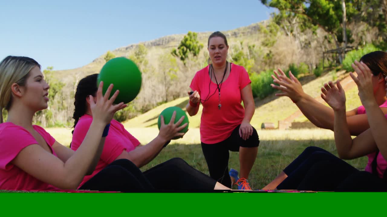 entrenadora que instruye a las mujeres mientras hacen ejercicio durante una carrera de obstáculos