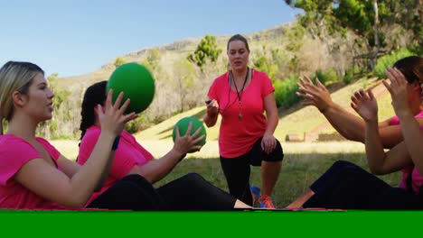 Entrenadora-Femenina-Instruyendo-A-Las-Mujeres-Mientras-Hacen-Ejercicio-Durante-La-Carrera-De-Obstáculos