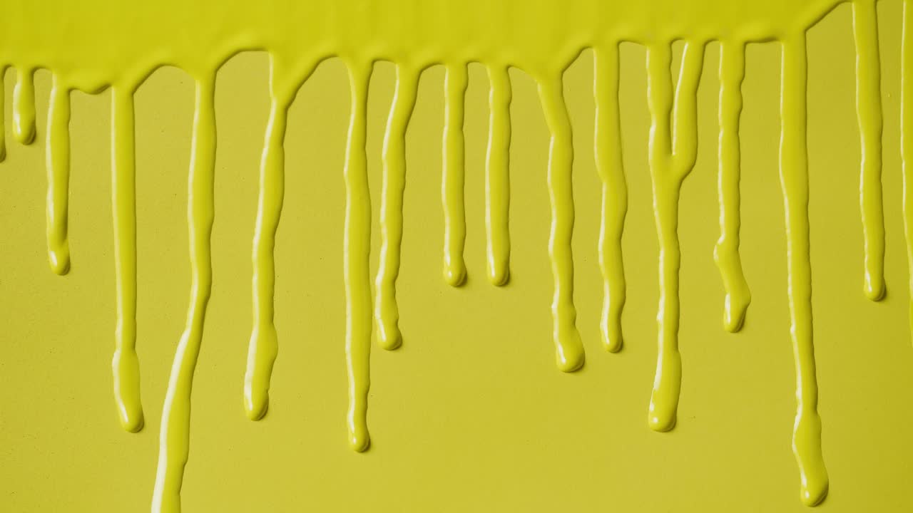 Bright Yellow Paint Dripping Down a Smooth Surface