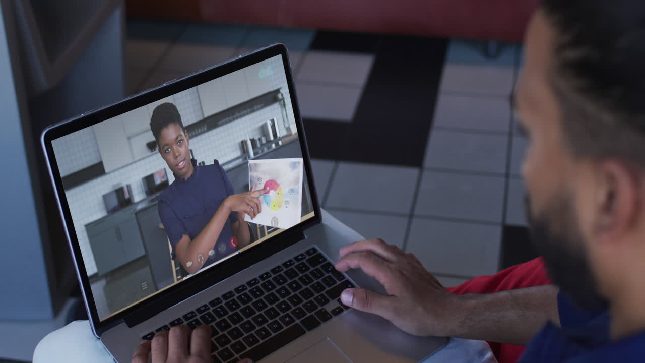 Middle eastern man having a video call with female office colleague on laptop