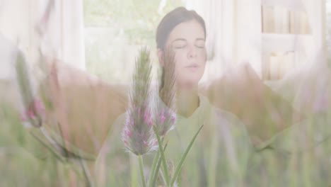 Animation-of-meadow-over-woman-exercising-and-meditating-at-home