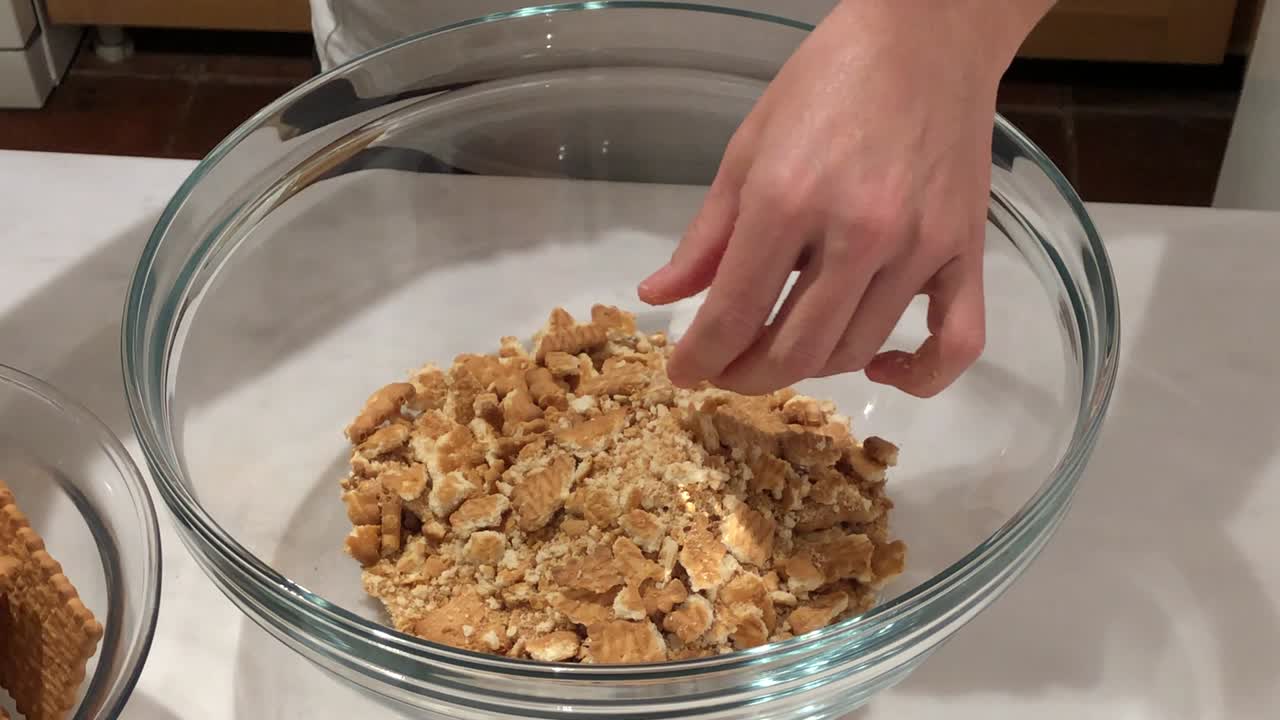 mujer preparando pastel de galleta en un cuenco de vidrio