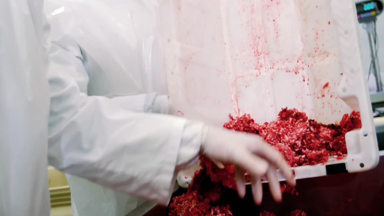 carniceros que ponen la carne picada en el recipiente