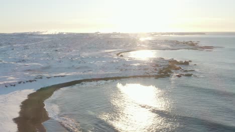 驚人的中午陽光照耀著冰島被雪覆蓋的荒野海岸