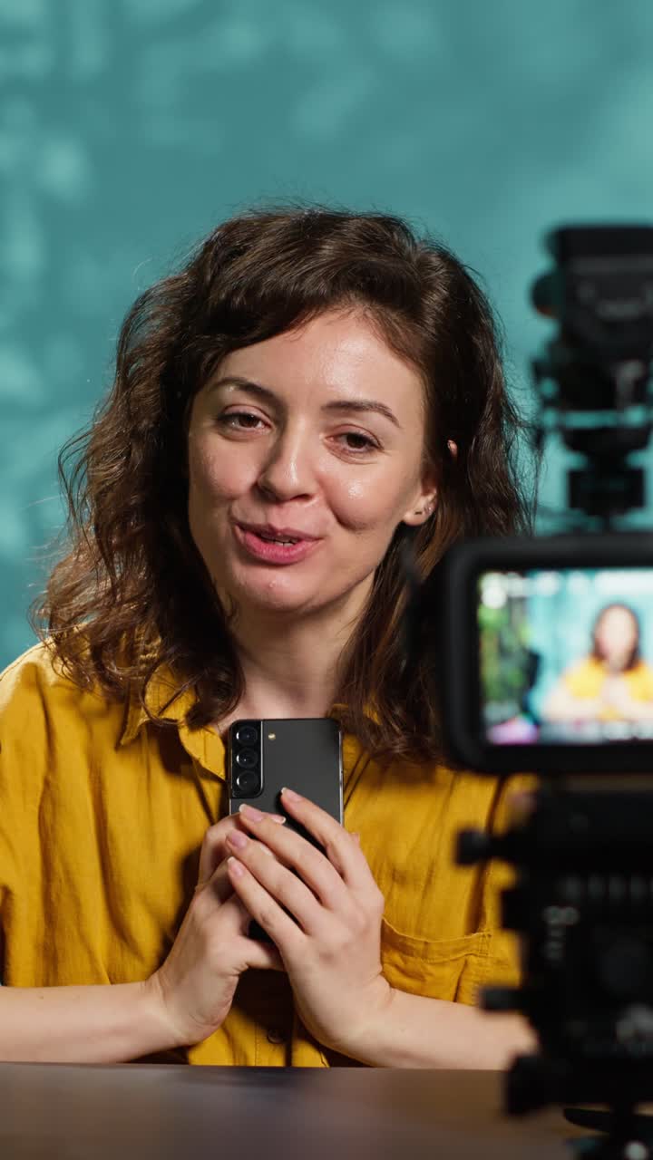 Vlogger Wanita Muda Merekam Video dengan Smartphone dan Kamera