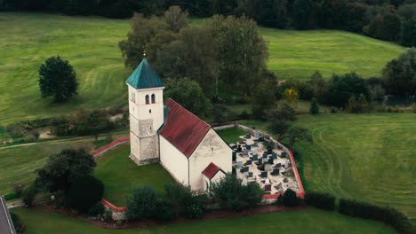 a quaint countryside church surrounded by lush greenery, overcast sky, aerial view