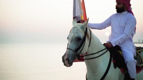 a knight on horse holding qatar flag near the sea-4