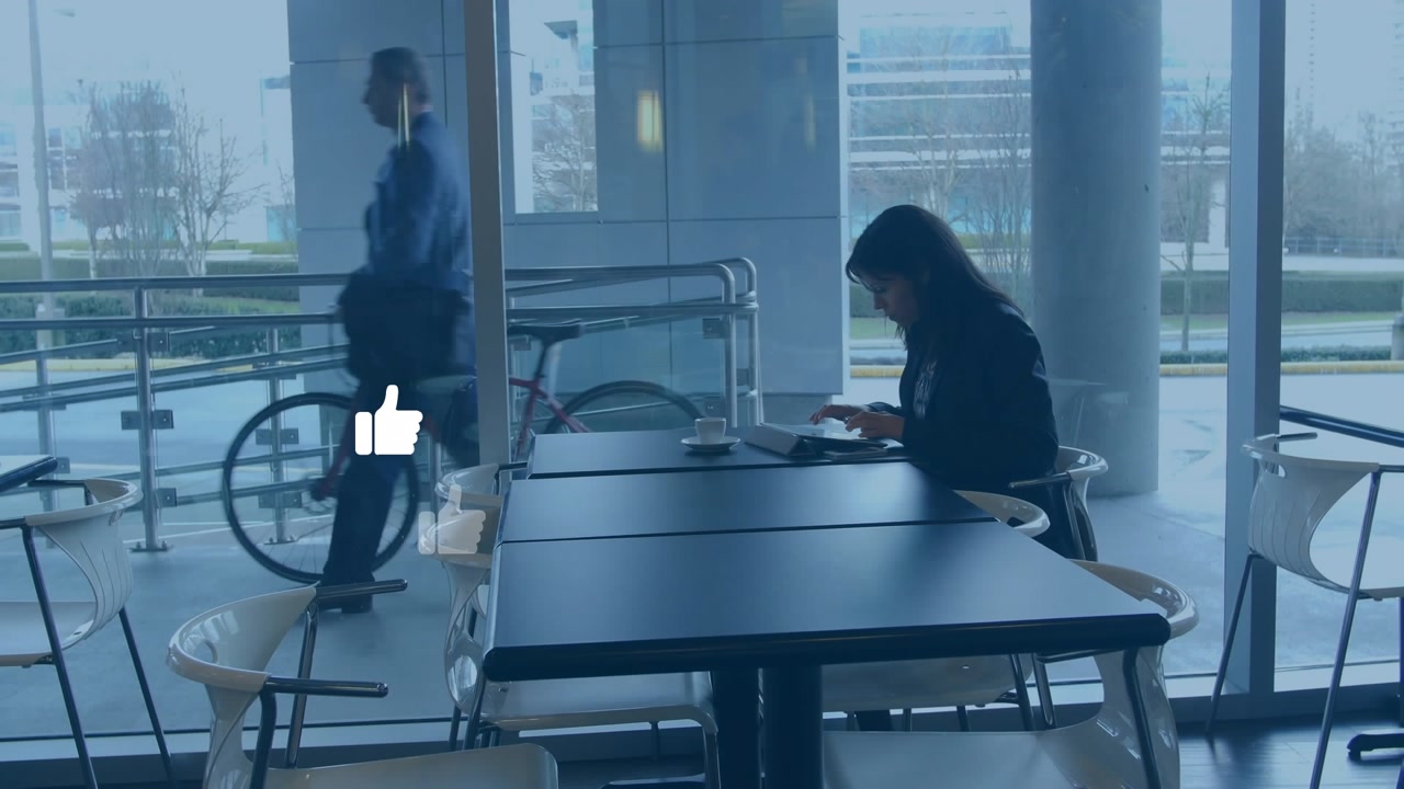 Animation of thumbs up icons over woman using digital tablet at office