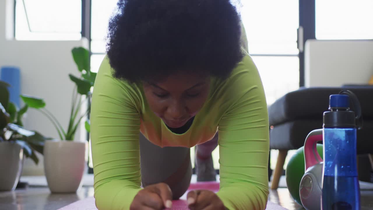 African american female plus size lying on exercise mat working out