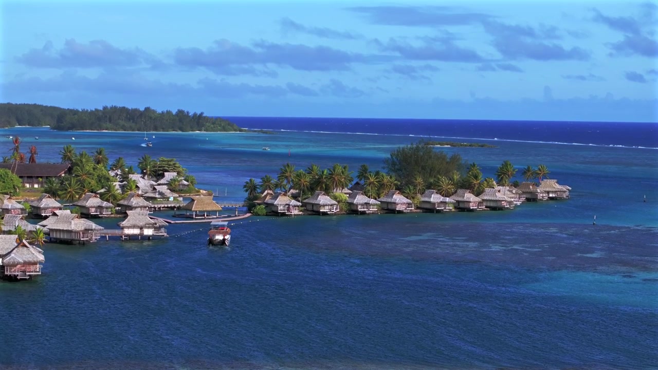 Motorbåd, bungalows på Moorea over koralrev, havkanal, tropiske øer, Fransk Polynesien, luftfoto fra drone, Tahiti, Bora Bora, Opunohu Bugt, Ta'ahiamanu Offentlige Strand, dagtid, solrig blå himmel, cirkulær panorering opad.