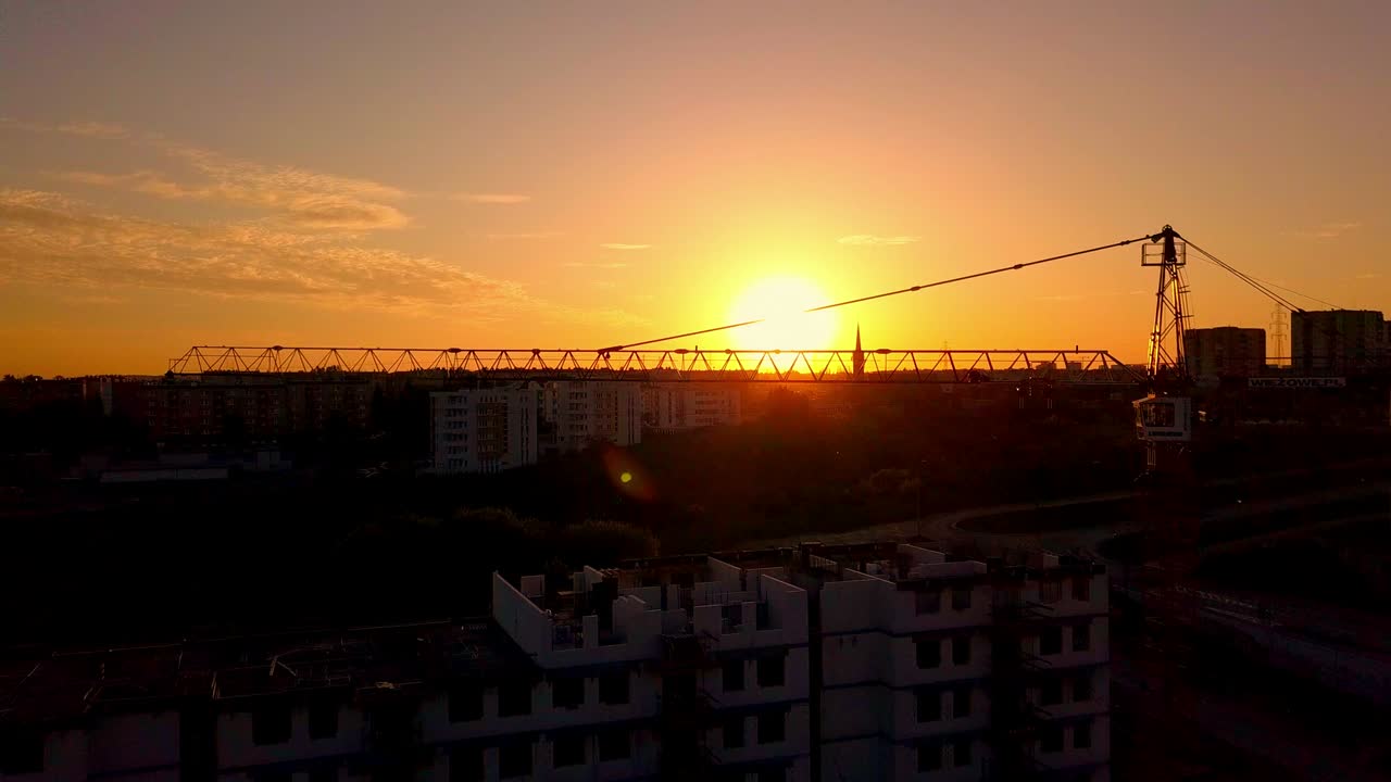 Vista Aérea de Canteiro de Obras e Guindastes ao Pôr do Sol.