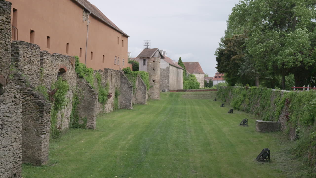Medieval stone wall along grassy courtyard