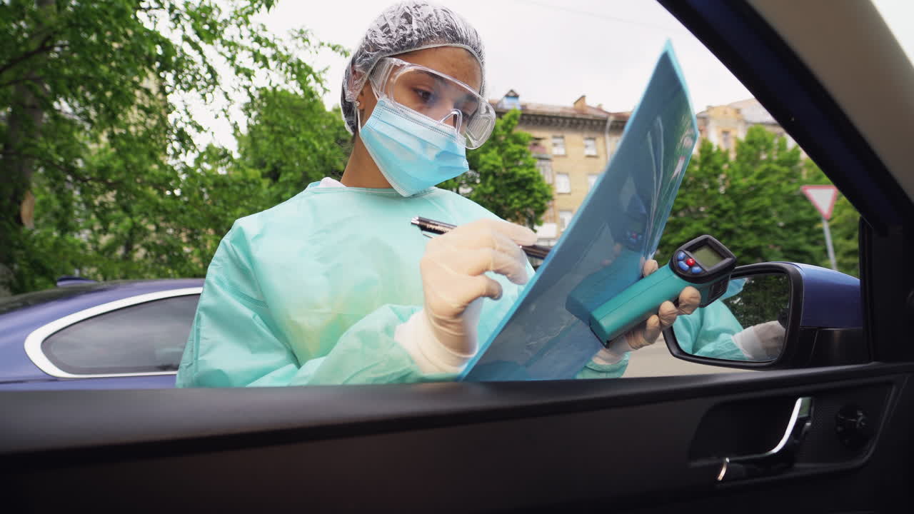 comprobación médica profesional de la temperatura en la ventana del automóvil