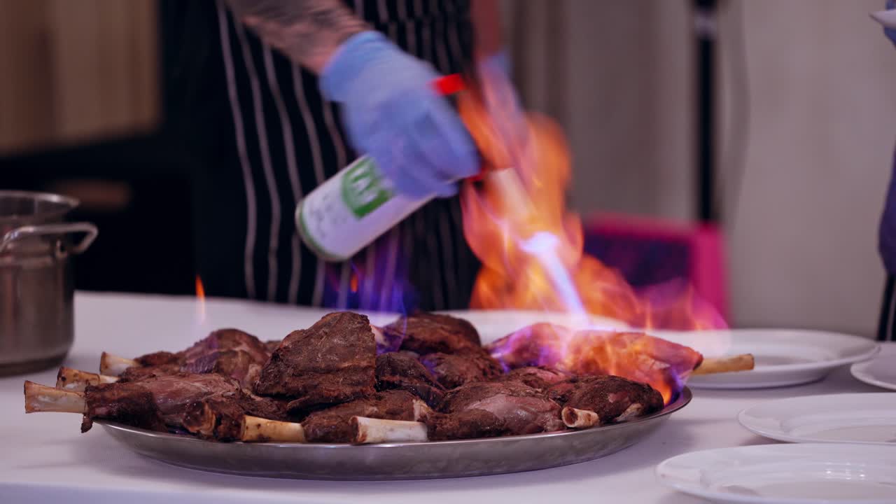 Burning meat on table. Close up view of waiter burning meat in restaurant