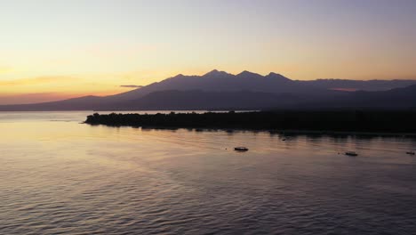 Puesta-De-Sol-Amarilla-A-Través-De-Un-Gran-Cuerpo-De-Agua-Con-Una-Pequeña-Isla-Y-Montañas