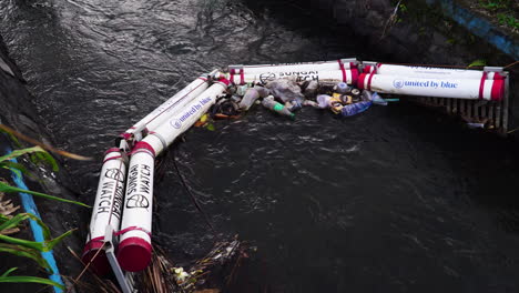 boom barrier on the river stopping plastic waste from spilling out into the sea