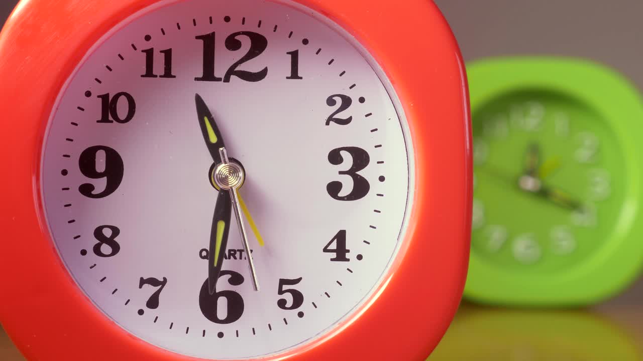 Retrato de plazo, Tiempo, concepto - dos relojes de colores marcando el tiempo juntos