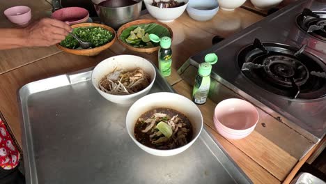 sequential preparation of boat noodle soup bowls