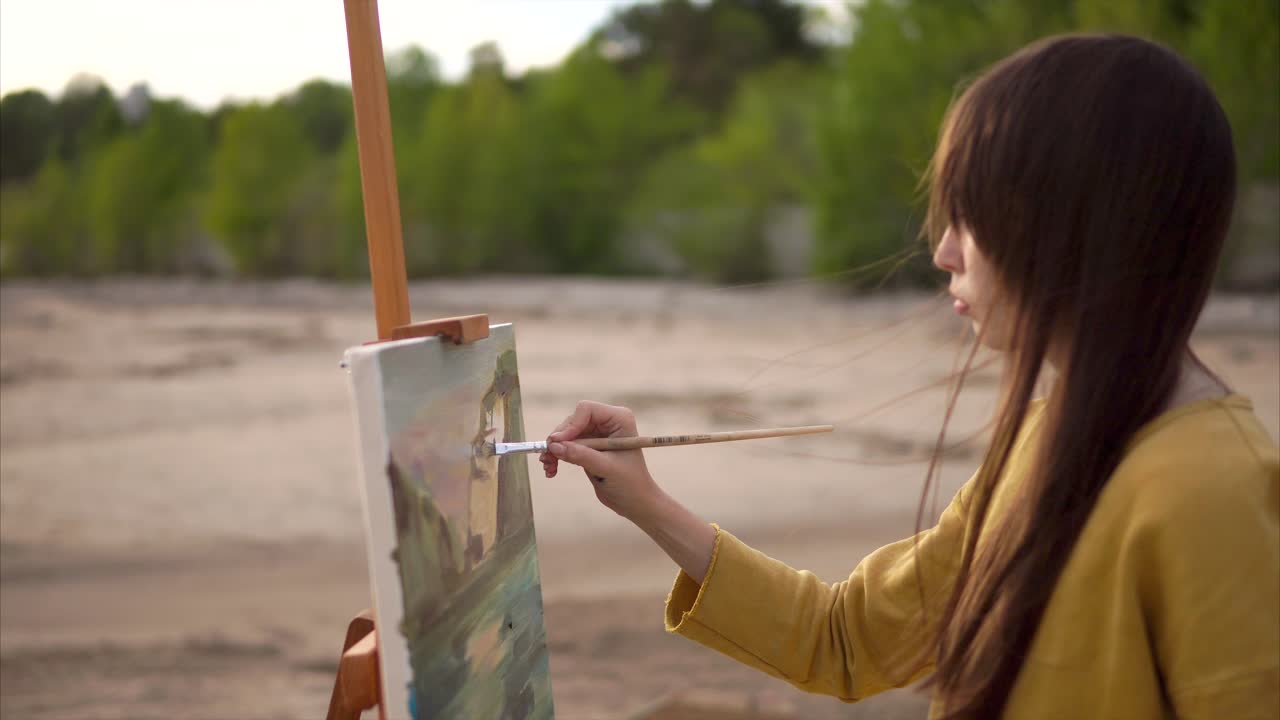 Woman painting a landscape on a beach