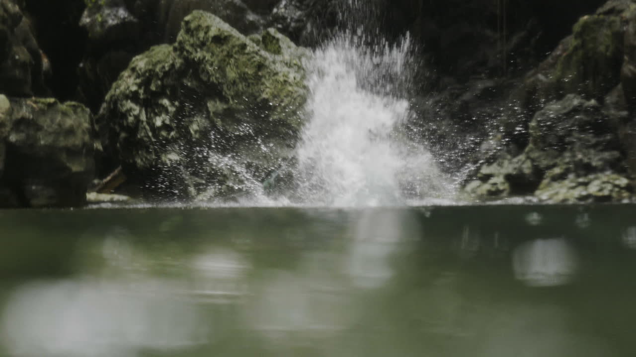 Jumping into a Waterfall in a Lush Jungle