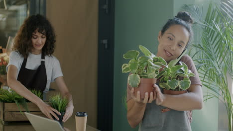 woman talking on phone while showing plants in a store