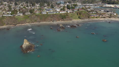 aerial circling shot of sea stacks and harbor jetty entrance