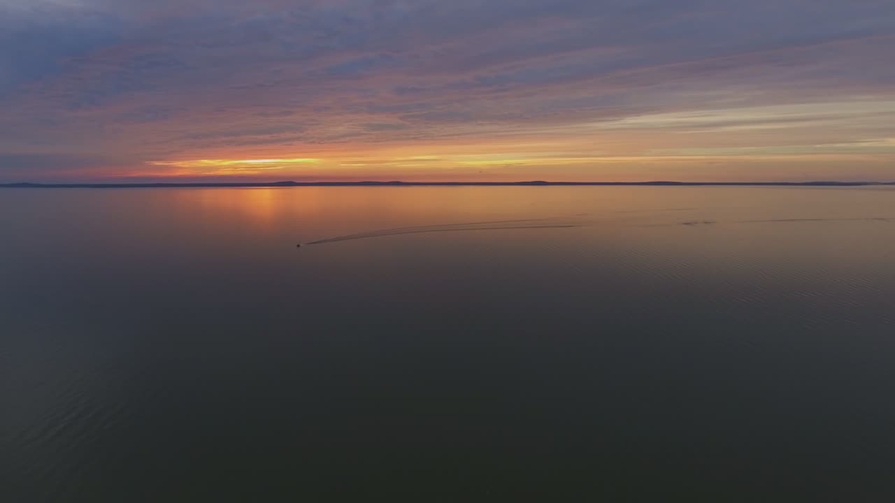 моторная яхта, плывущая по куршской лагуне во время заката солнца