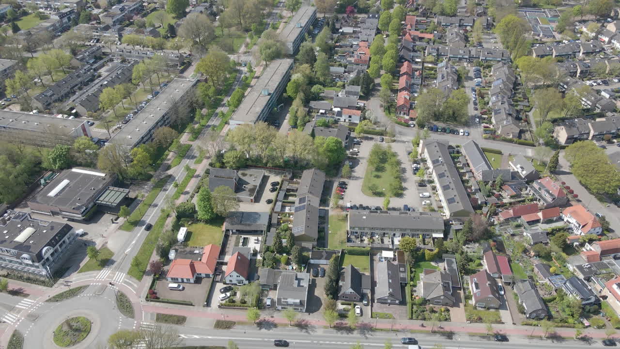 분주한 로터리가 있는 작은 교외 마을의 공중
